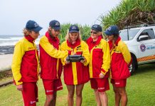 a group of lifeguards looking at a drone