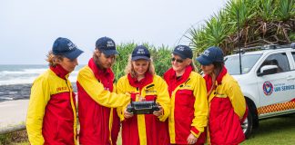 a group of lifeguards looking at a drone