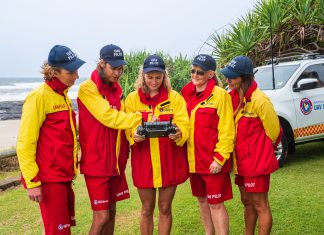 a group of lifeguards looking at a drone