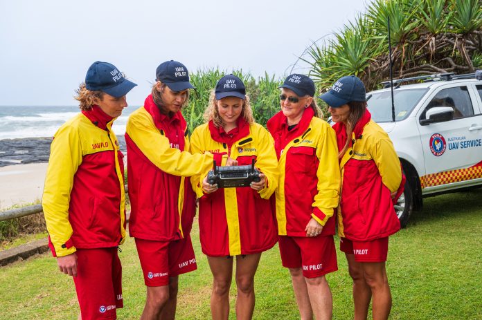 a group of lifeguards looking at a drone