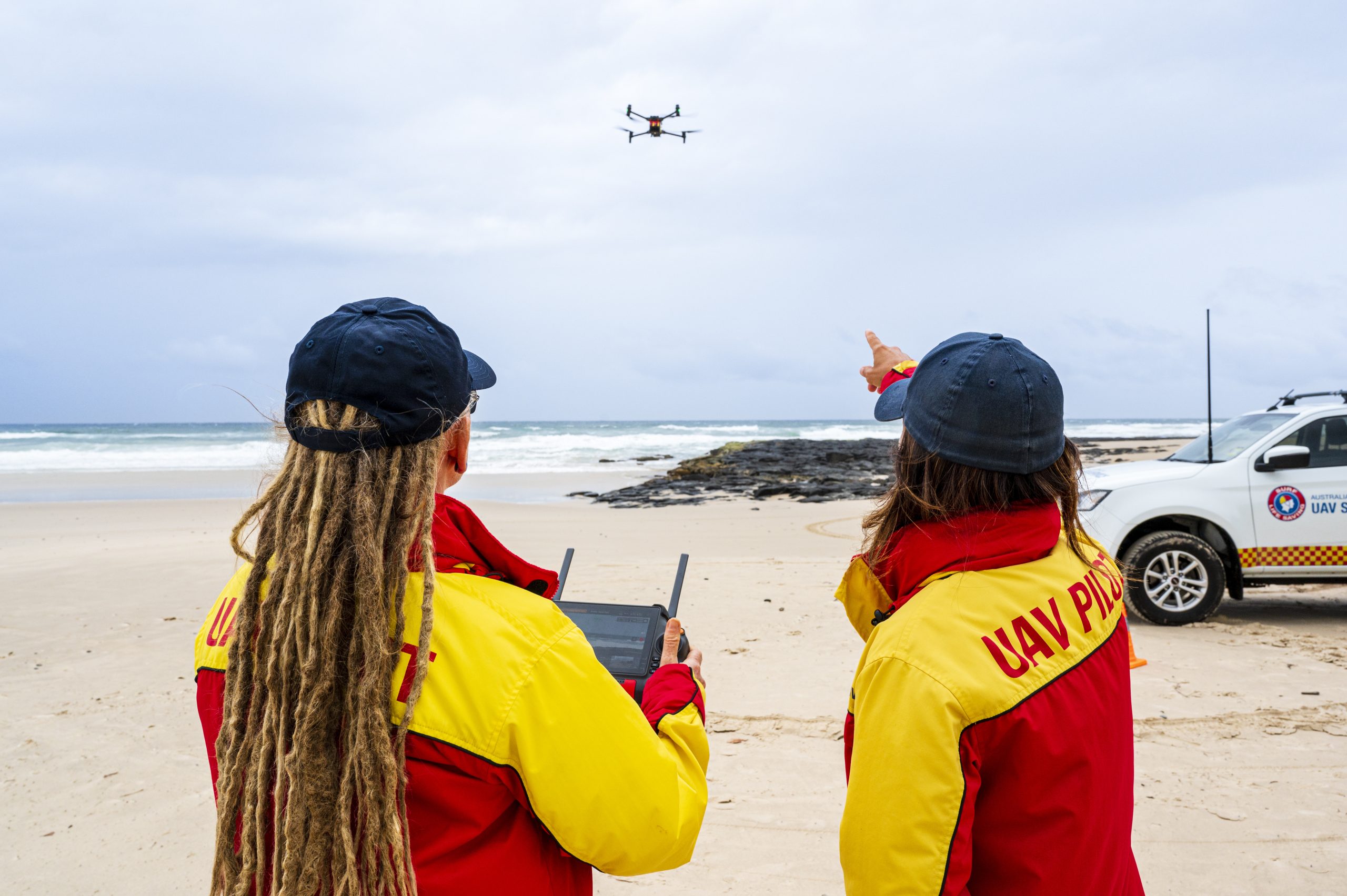 Life guards looking at a drone
