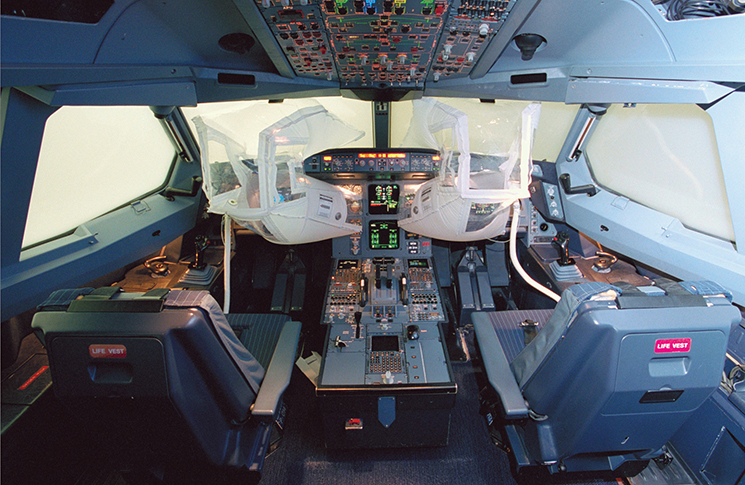 Photo of a cockpit with an emergency vision assurance system allows a pilot to see instrument displays and through windows in a smoke-filled flight deck