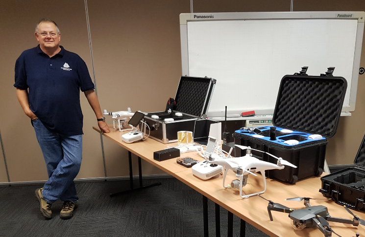 image of Martin Bass beside a table of drones