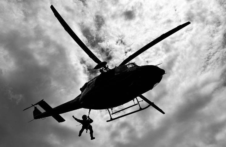 Daniel hanging out of helicopter