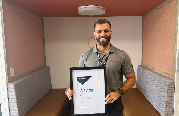 Daniel in the Cairns CASA office holding up a certificate