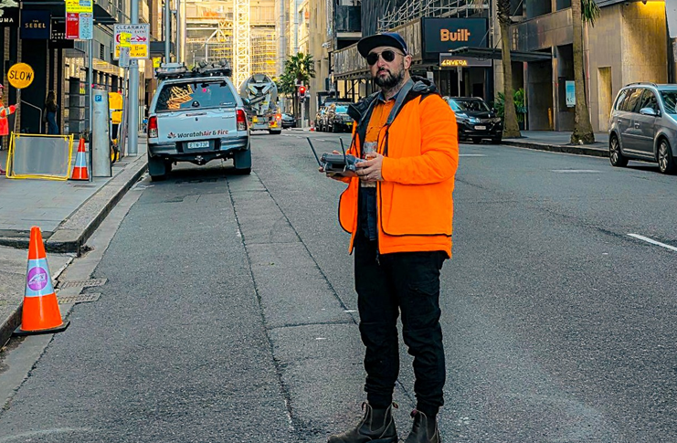 Danny Elassad flying a drone on a city street.