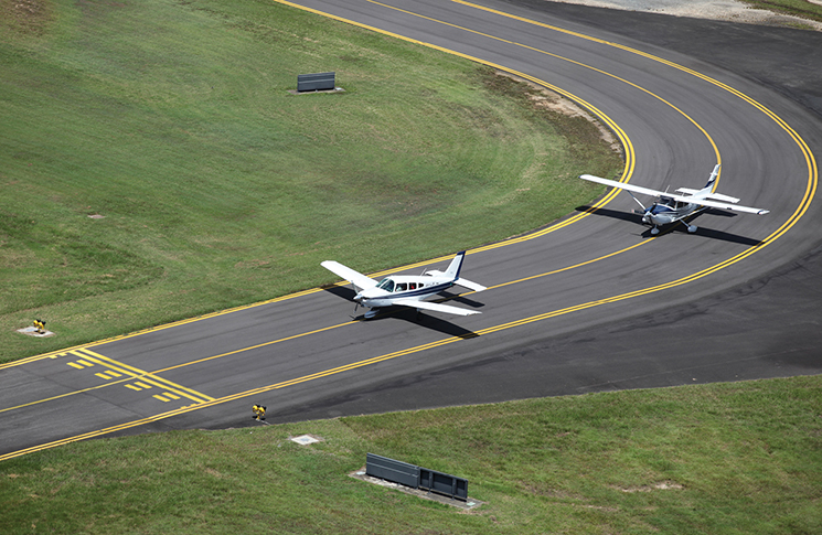 Two airplanes driving along a bend in a taxiway