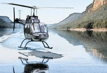 To a mirror finish A helicopter hovering over mirror-smooth lake water