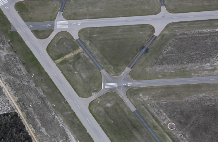Aerial view of intersecting runways 06L and 12 at Jandakot Aerodrome and taxiway Sierra crossing the threshold of runway 06R, showing multiple holding points and complex ground movement areas where pilots must maintain situational awareness.