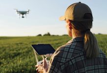 A woman flying a drone over a field