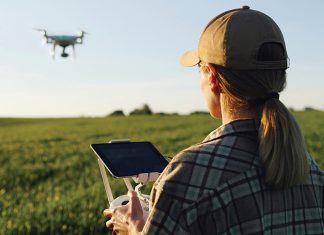 A woman flying a drone over a field