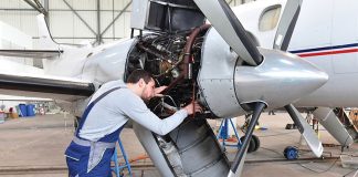 A maintenance engineer examines an aeroplane's engine