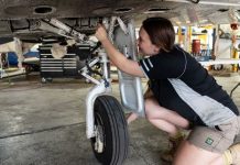 Female aircraft maintainer working on a Piper PA-31 aircraft.
