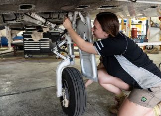 Female aircraft maintainer working on a Piper PA-31 aircraft.