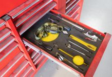 A set of tools sitting in their individual spaces in a red toolbox