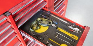 A set of tools sitting in their individual spaces in a red toolbox