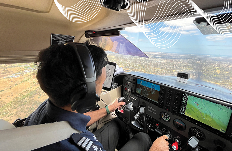 A man flies an aeroplane, with the desert visible through the windows