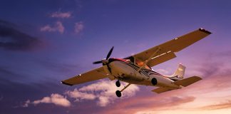 Long day’s journey into night VFR A small aeroplane is flying against a colourful sky at sunset with scattered clouds