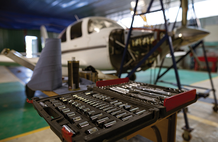 Quiz maintenance spring 2026 1 An open toolbox in a hangar with an aeroplane under maintenance behind it