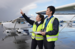 Weather decisions: keep your options open Two pilots in high-visibility vests stand beside a light aircraft on a wet tarmac, looking towards approaching dark clouds.